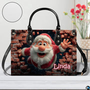 Holiday Santa themed handbag displayed on white surface beside floral arrangement.