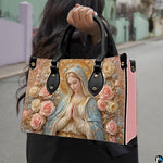 Side profile view of structured Madonna handbag showing silhouette and black carry handles