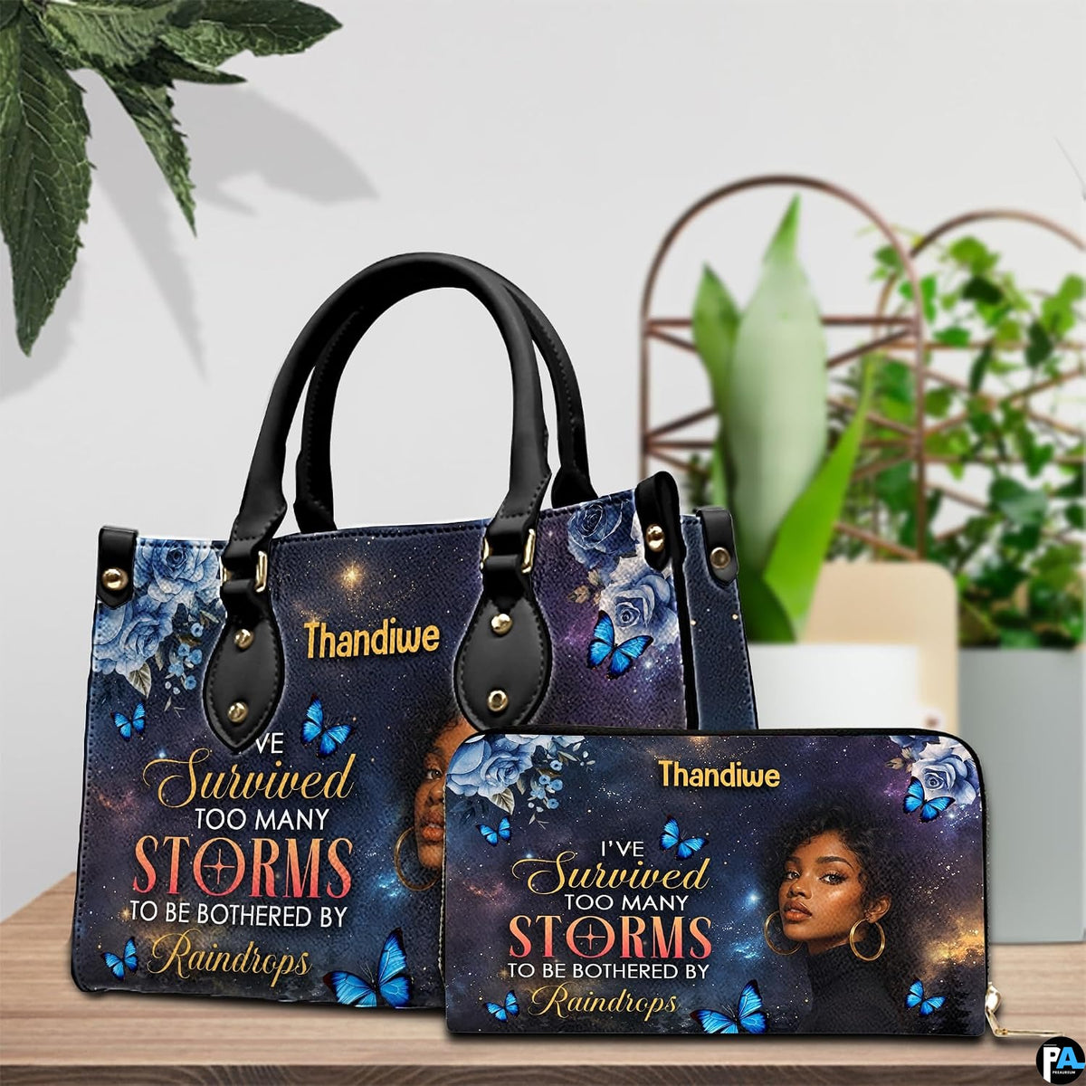 Tabletop presentation highlighting celestial woman painting resting beside leafy indoor greenery.