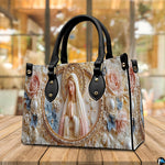 Lifestyle display showing handheld carry of the pearl cameo handbag in an outdoor setting.