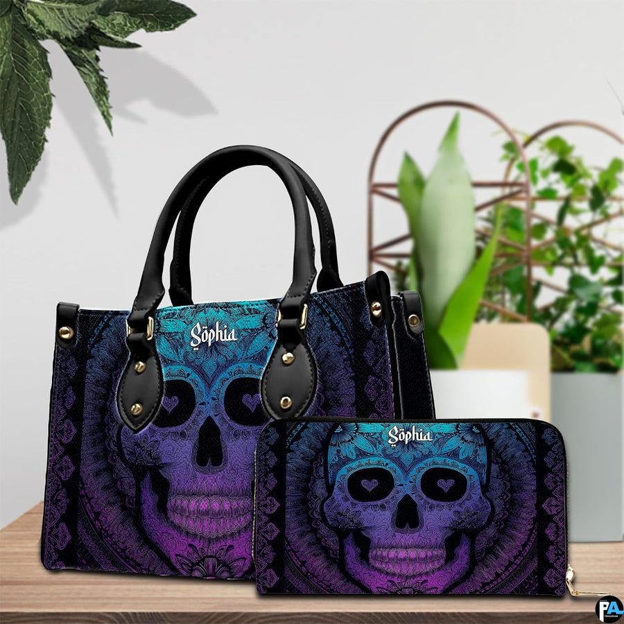 Sugar skull handbag and wallet displayed on wooden table beside potted plant.