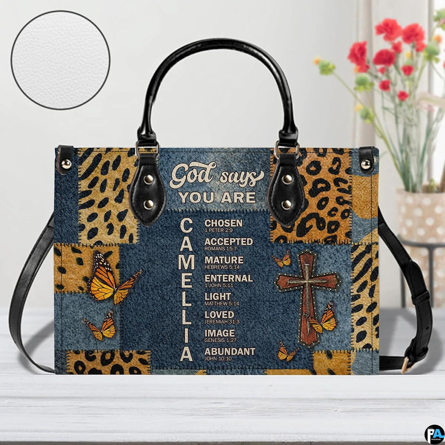 Home lifestyle view of Christian cross butterfly handbag on white table beside decorative flowers