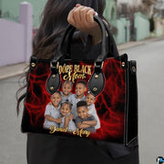 Front view of crimson handbag featuring smiling portrait against glowing electric red lightning backdrop.