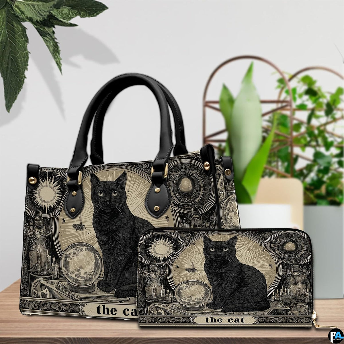 Tabletop scene presenting vintage cat tarot artwork resting on wood beside green houseplants.