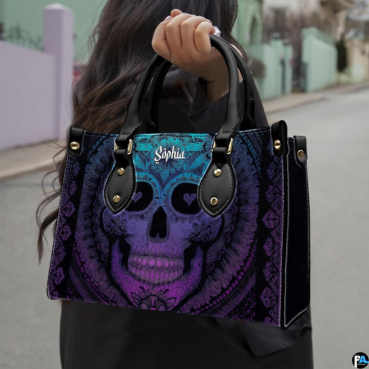Sugar skull handbag carried outdoors by top handle on residential street.