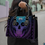 Sugar skull handbag carried outdoors by top handle on residential street.