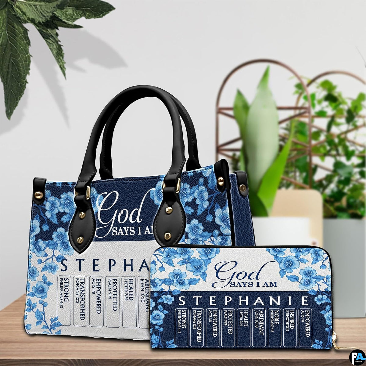 Blue porcelain floral artwork and matching companion accessory shown on wooden surface with indoor greenery.