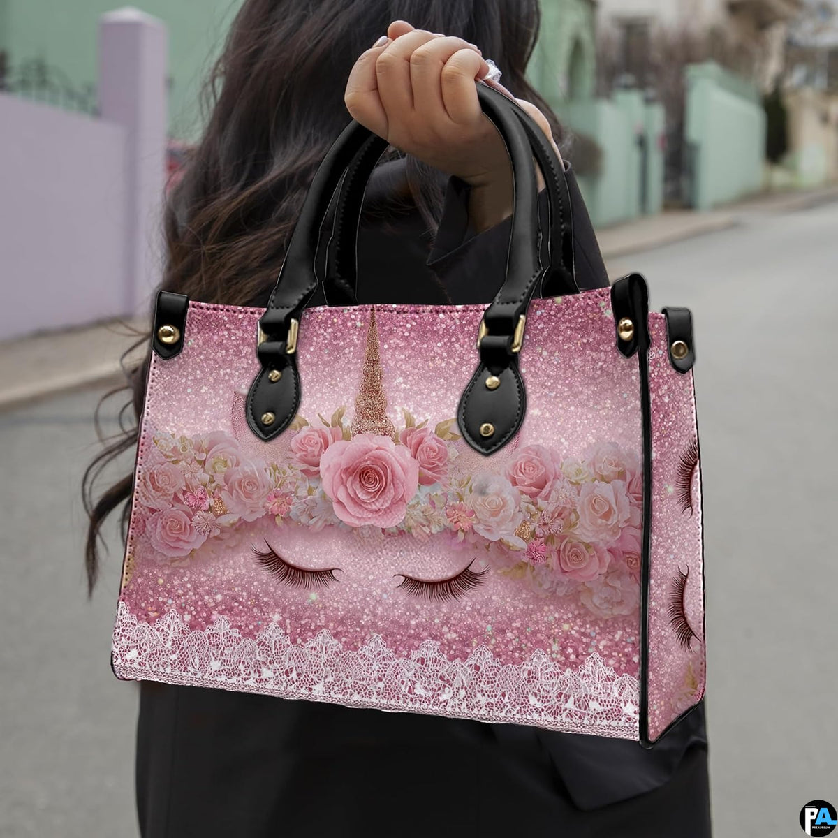 Side profile of pastel unicorn handbag showing structured silhouette and black carrying handles.