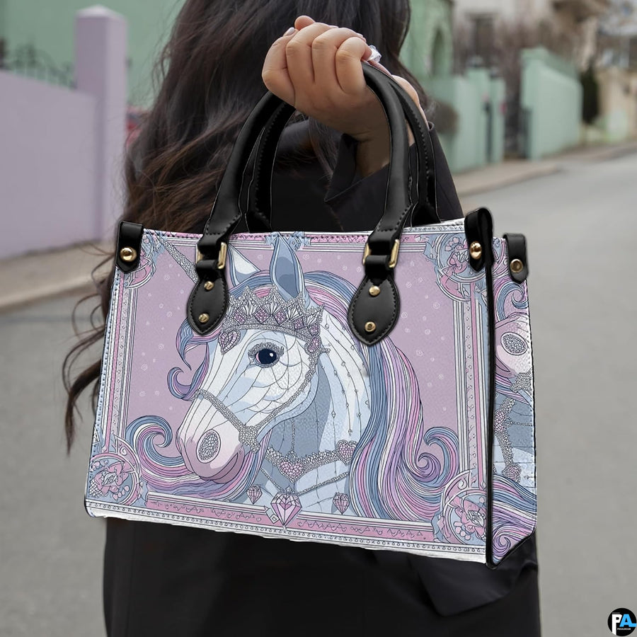 Side profile of unicorn handbag showing structured silhouette and black carrying handles.