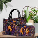 Pair showcase featuring gothic witch artwork placed on wooden tabletop beside potted plant.