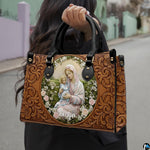 Lifestyle display of tooled floral Madonna handbag carried by model showing artwork and scale