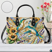 Back view of mosaic hummingbird handbag showing continuous floral pattern on white background.