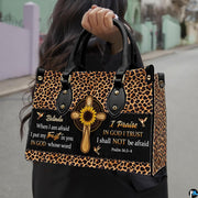 Detailed view of woodgrain cross, bright sunflower petals, and leopard print border bands on handbag.