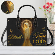 Front view of matching wallet displaying golden sacred figure, celestial halo, and butterfly accents.