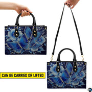 Top-down view of butterfly handbag showing dual handles and interior storage opening.