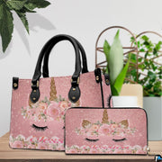 Side profile of floral unicorn handbag showing structured shape and black carrying handles.