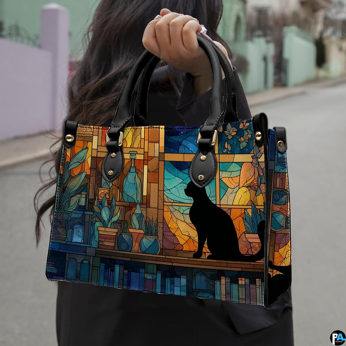 Cat stained glass panel design showcased outdoors along a sunlit paved street.