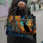 Cat stained glass panel design showcased outdoors along a sunlit paved street.