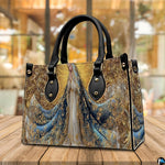 Lifestyle display showing handheld carry of the Marian handbag in an outdoor garden setting.