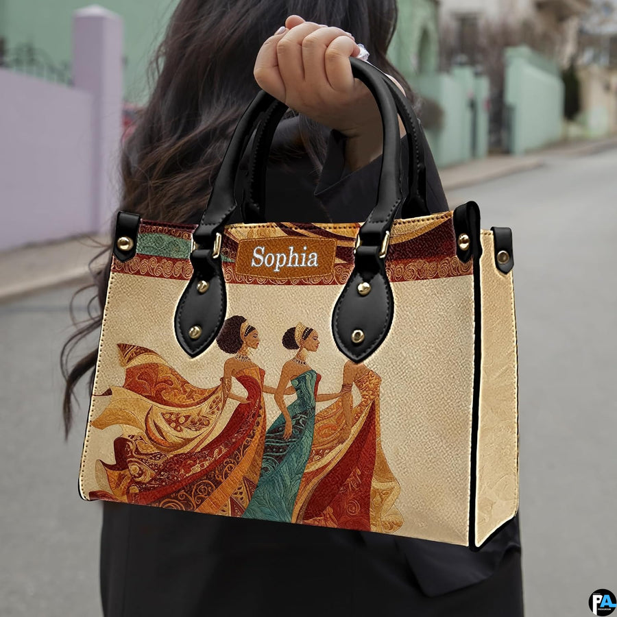 Outdoor street perspective of model carrying the regal African queen handbag by its top handles.