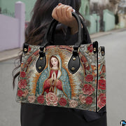 Model wearing arched Guadalupe handbag over shoulder with attached strap.