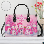 Front view of holiday snowman handbag on white surface next to floral decor with leather texture swatch.