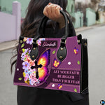 Model carrying the purple butterfly cross handbag with black top handles in an outdoor setting