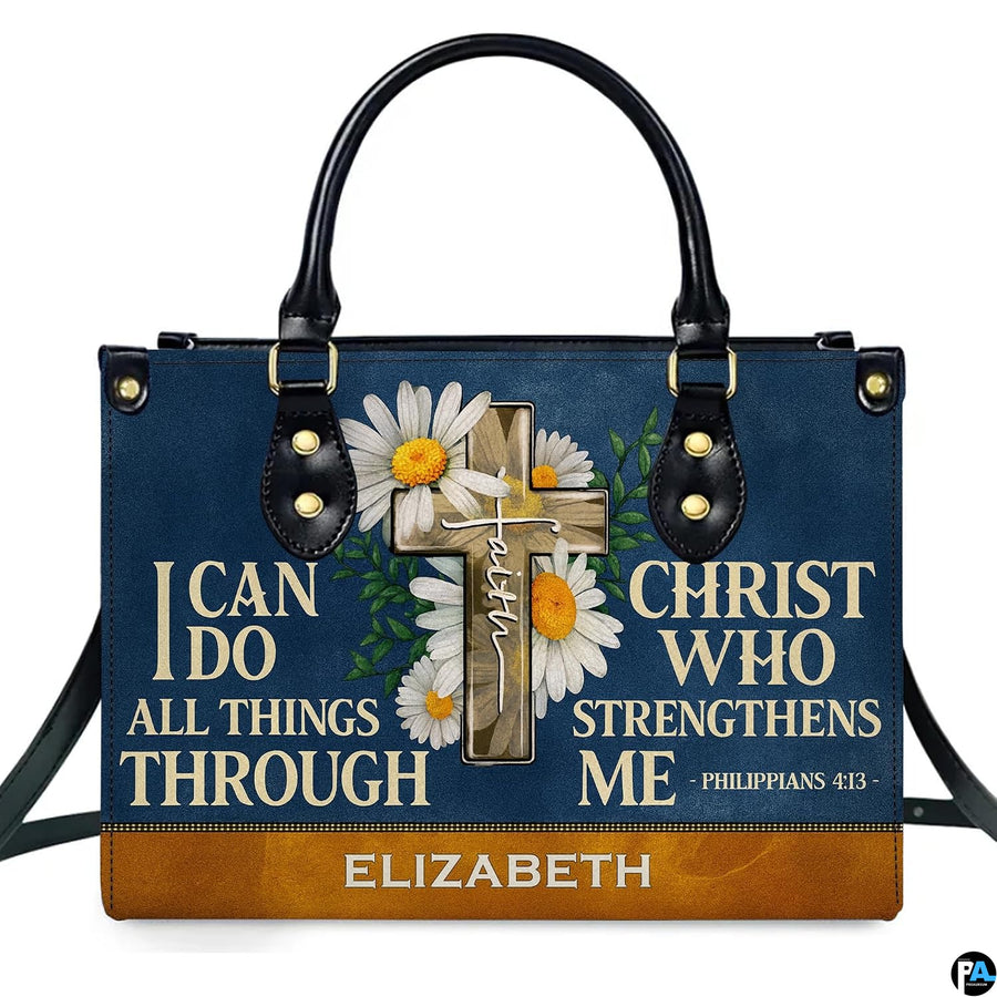 Frontal view of navy handbag showcasing a wooden cross with white daisies, green leaves, and devotional verse lettering.