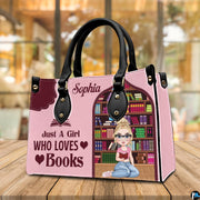 Three-quarter perspective view of pink reading girl handbag on a rustic wooden table.