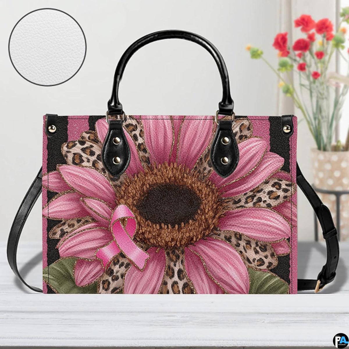 Tabletop presentation of pink sunflower art accessory resting on smooth wooden surface alongside circular texture inset.
