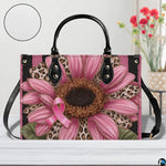 Tabletop presentation of pink sunflower art accessory resting on smooth wooden surface alongside circular texture inset.