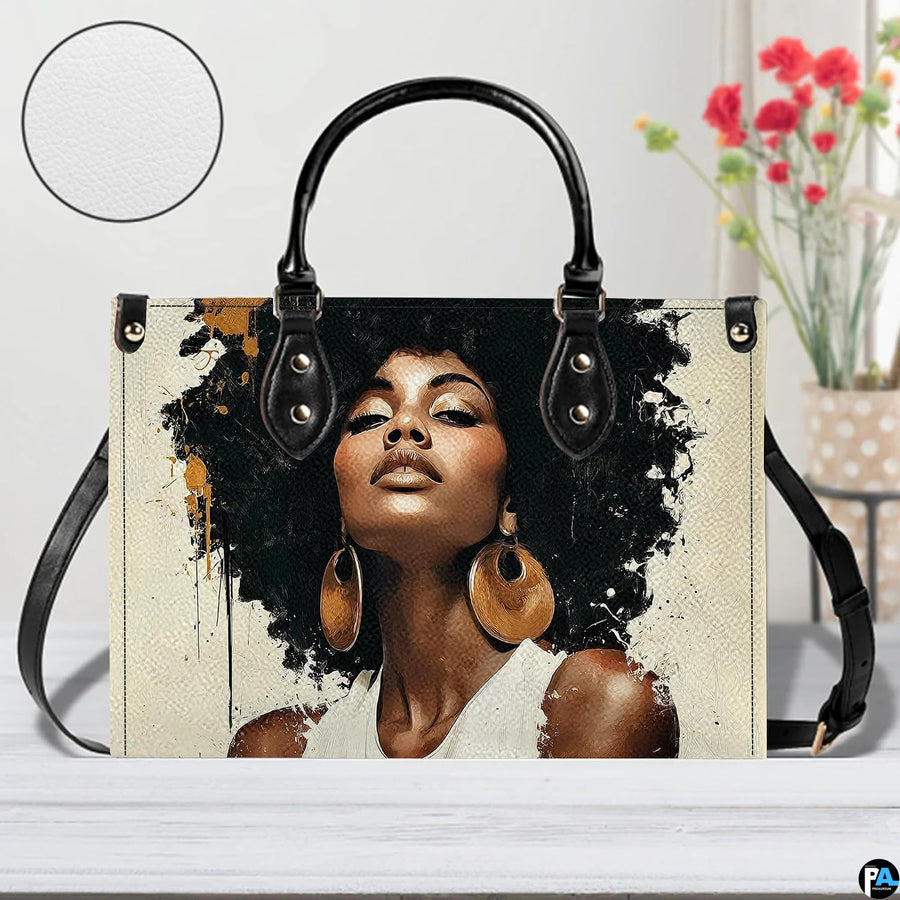 Front view of paint splash afro portrait handbag with black trim and gold accents