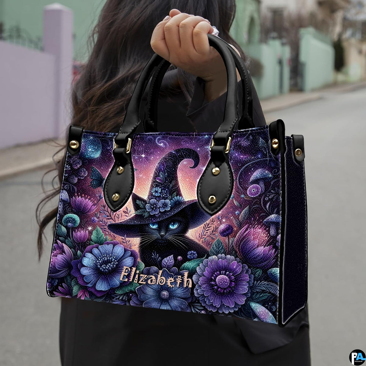Outdoor perspective showing floral witch cat artwork held over arm by pedestrian along city sidewalk.