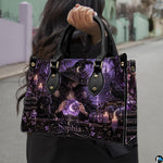 Gothic witch handbag carried outdoors by top handle on residential street.