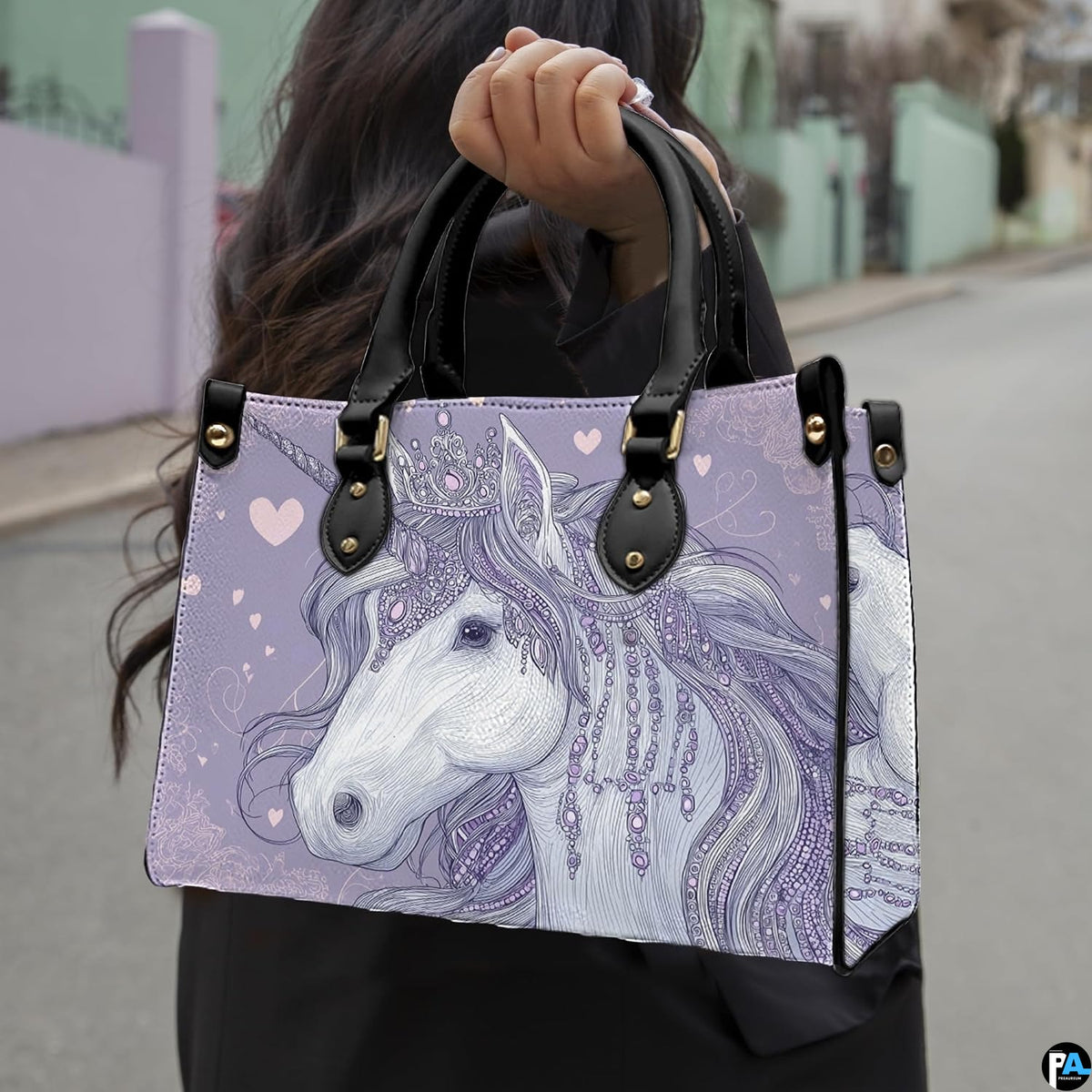 Side profile of crowned unicorn handbag showing structured silhouette and black carrying handles.