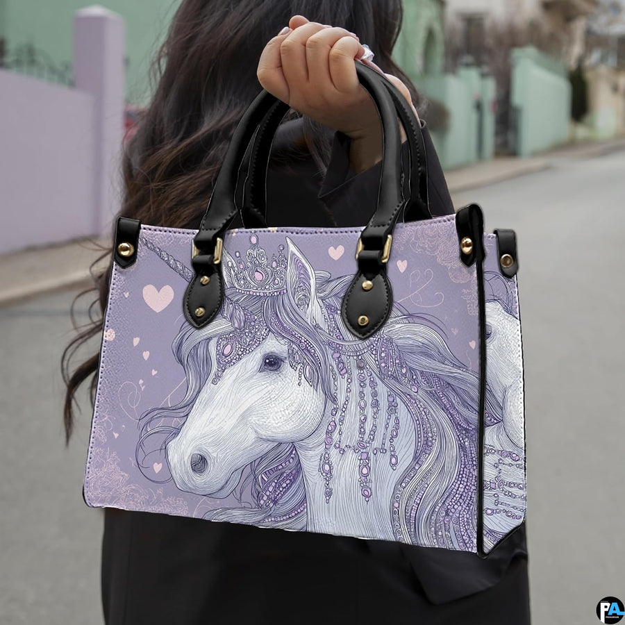 Side profile of crowned unicorn handbag showing structured silhouette and black carrying handles.