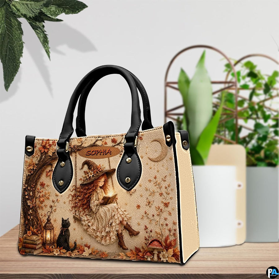 Autumn witch satchel displayed on wooden table with green potted plants in background.