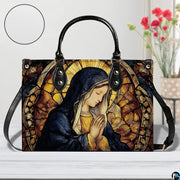Devotional stained glass handbag staged indoors beside a decorative flower vase
