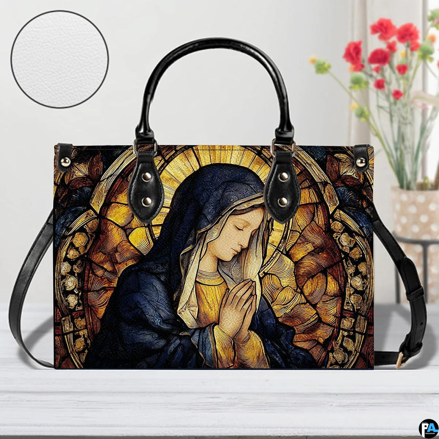 Devotional stained glass handbag staged indoors beside a decorative flower vase