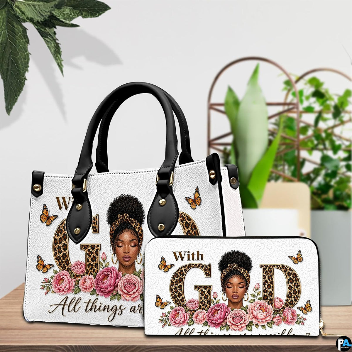 Tabletop presentation showing the floral faith artwork and matching accessory standing beside green house plants.