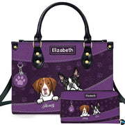Front view of purple dog lover handbag and matching wallet featuring illustrated peeking pups and paw prints.