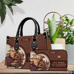 Handbag displayed alongside matching zippered wallet with golden dragon and floral artwork on a table