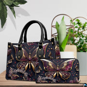 Close-up front view of handbag showing gold and plum butterfly wings