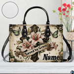 Front view of Easter lily cross handbag showing blooming lilies and green butterflies on parchment.