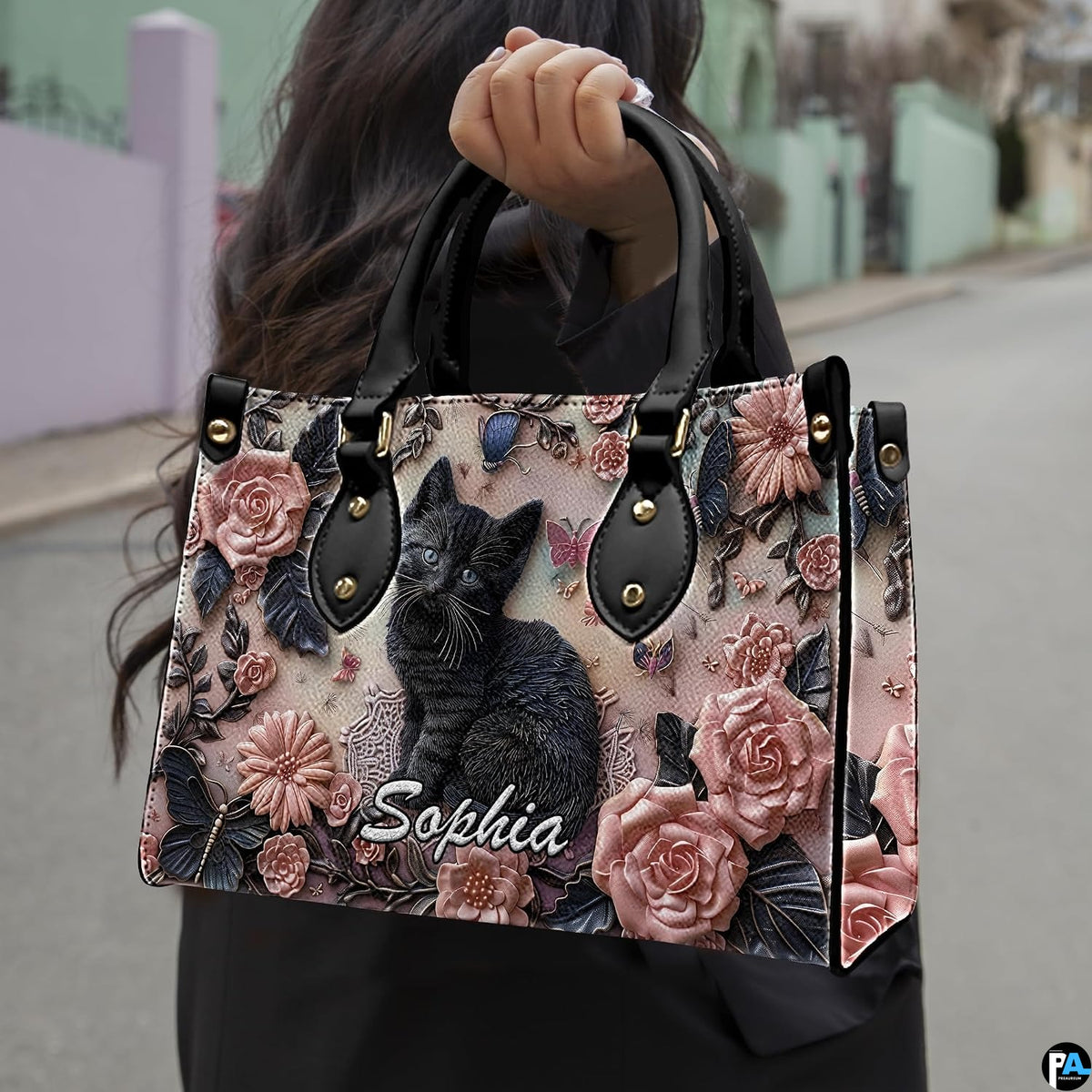 Perspective view of black kitten rose relief handbag and wallet pair