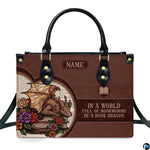 Front view of structured handbag featuring golden sleeping dragon, floral roses, and vintage printed book text