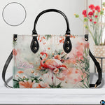 Side street view of model carrying the botanical flamingo floral handbag.