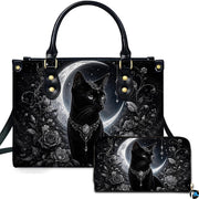 Studio view showcasing crowned black cat artwork alongside matching companion accessory on plain white surface.
