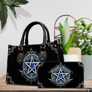 Gothic pentagram handbag and wallet on wooden table beside houseplant.
