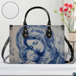 Devotional blue Madonna and Child handbag displayed on white table with background vase